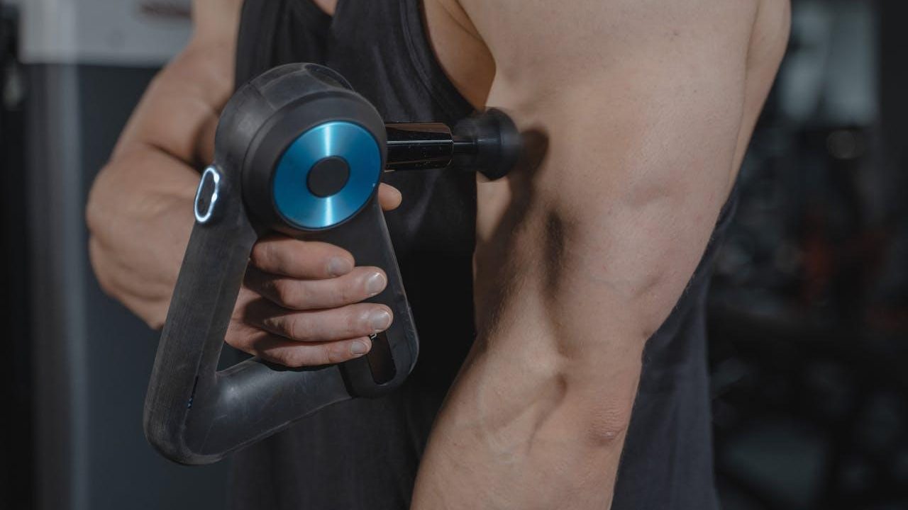 Pistola de masaje sobre el bíceps para descarga muscular