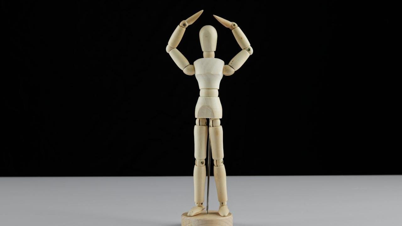 Maniquí de madera con los brazos arriba que muestra las articulaciones