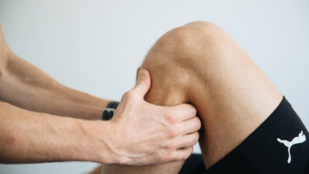 Manos sujetan una rodilla para mostrar la articulación