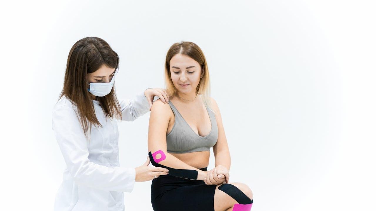 Fisioterapeuta coloca vendaje neuromuscular en la rodilla de una paciente