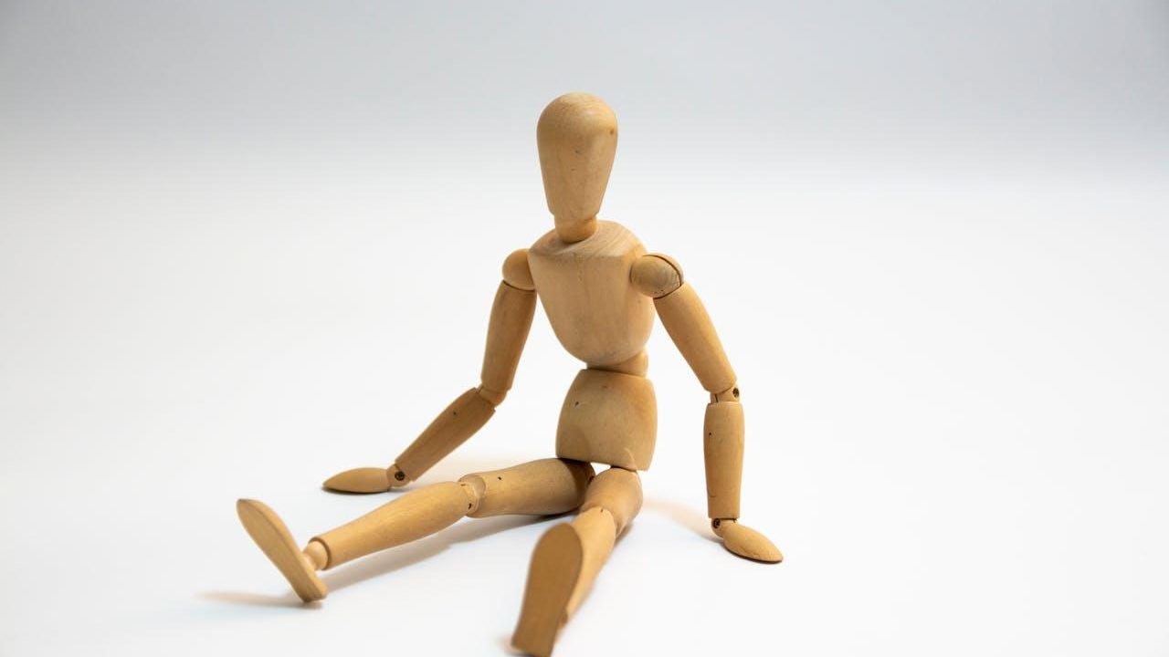 Maniquí de madera sentado que muestra articulaciones móviles