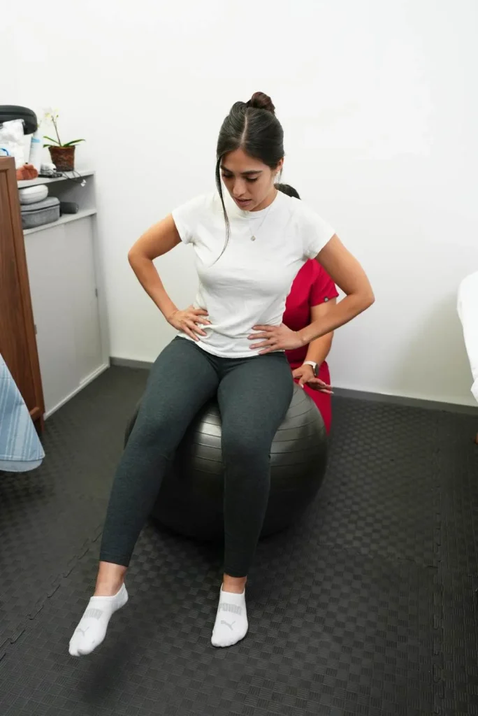 Paciente sentada en pelota terapéutica durante una sesión de rehabilitación en Puebla