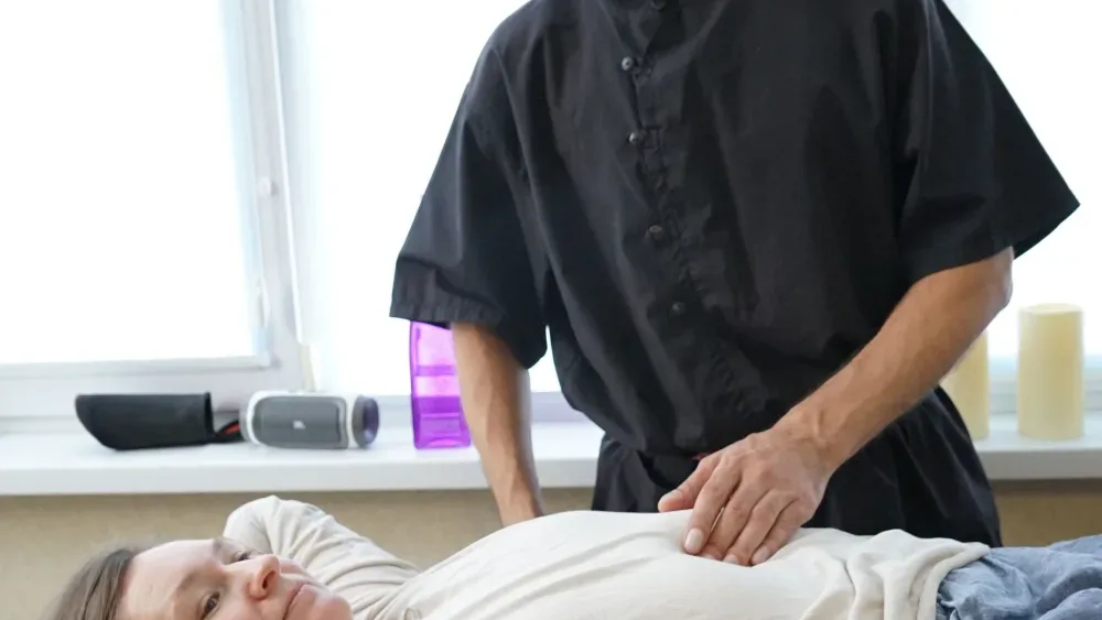 Terapeuta trabajando el abdomen en camilla