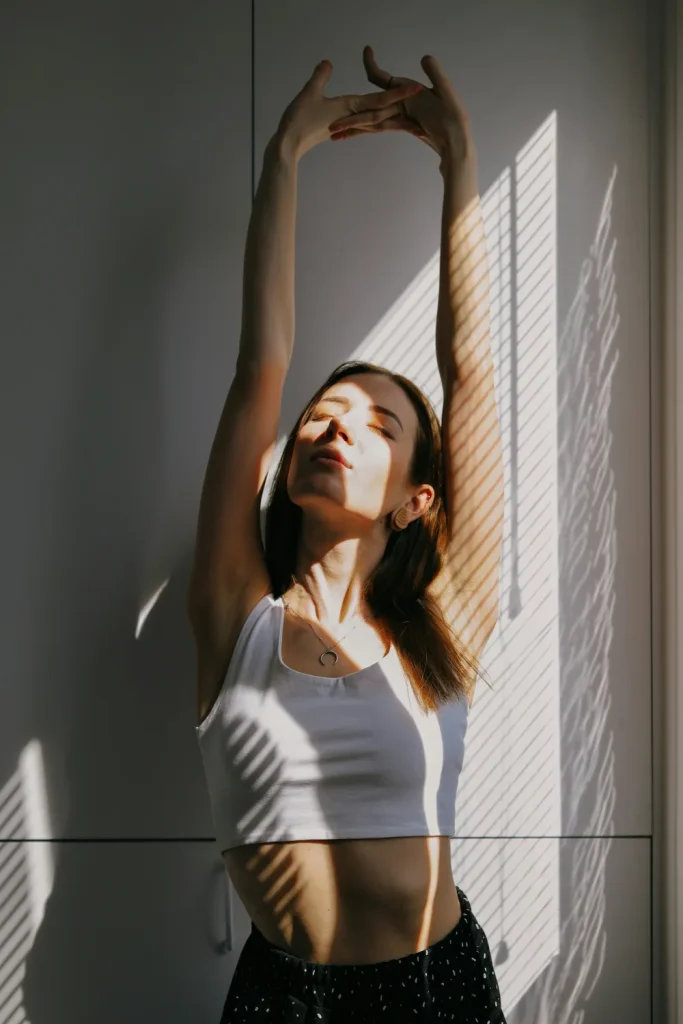 Masajes reductivos: beneficios posibles y mitos frecuentes 2 Mujer estirando los brazos junto a la ventana